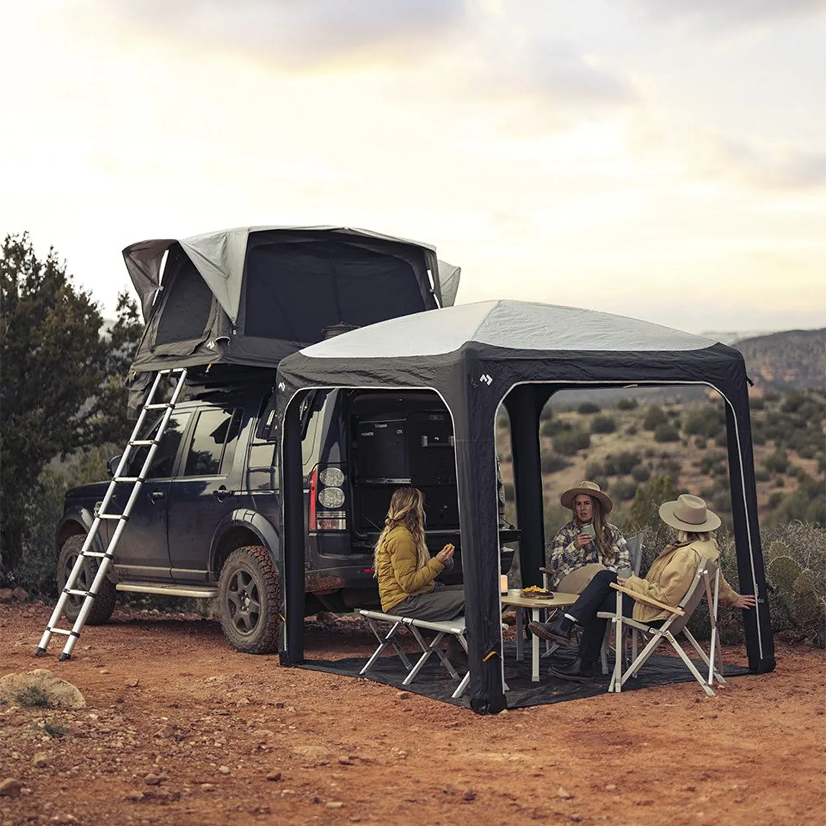 Dometic rooftop tent and inflatable awning set up on a Land Rover in the desert